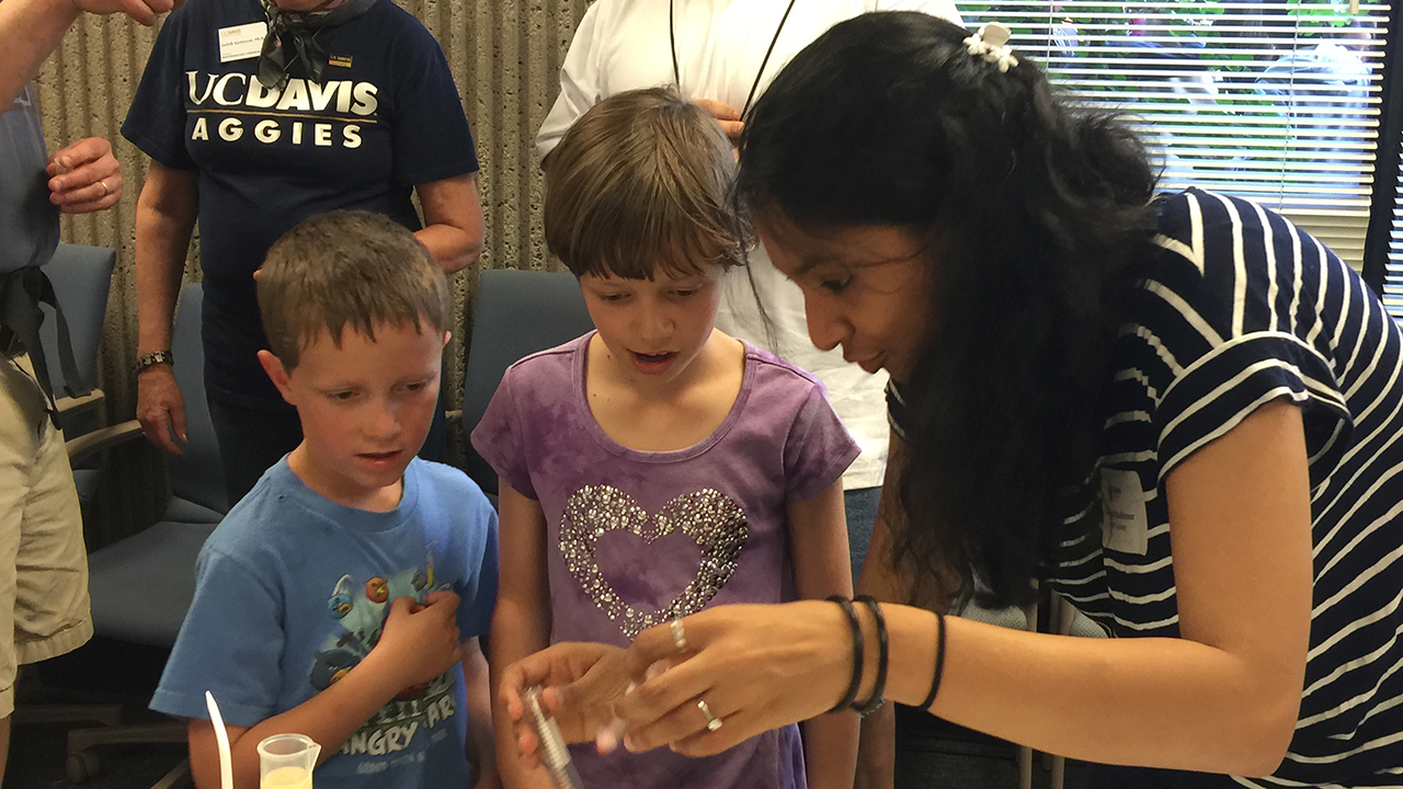 student works with young expierimenters